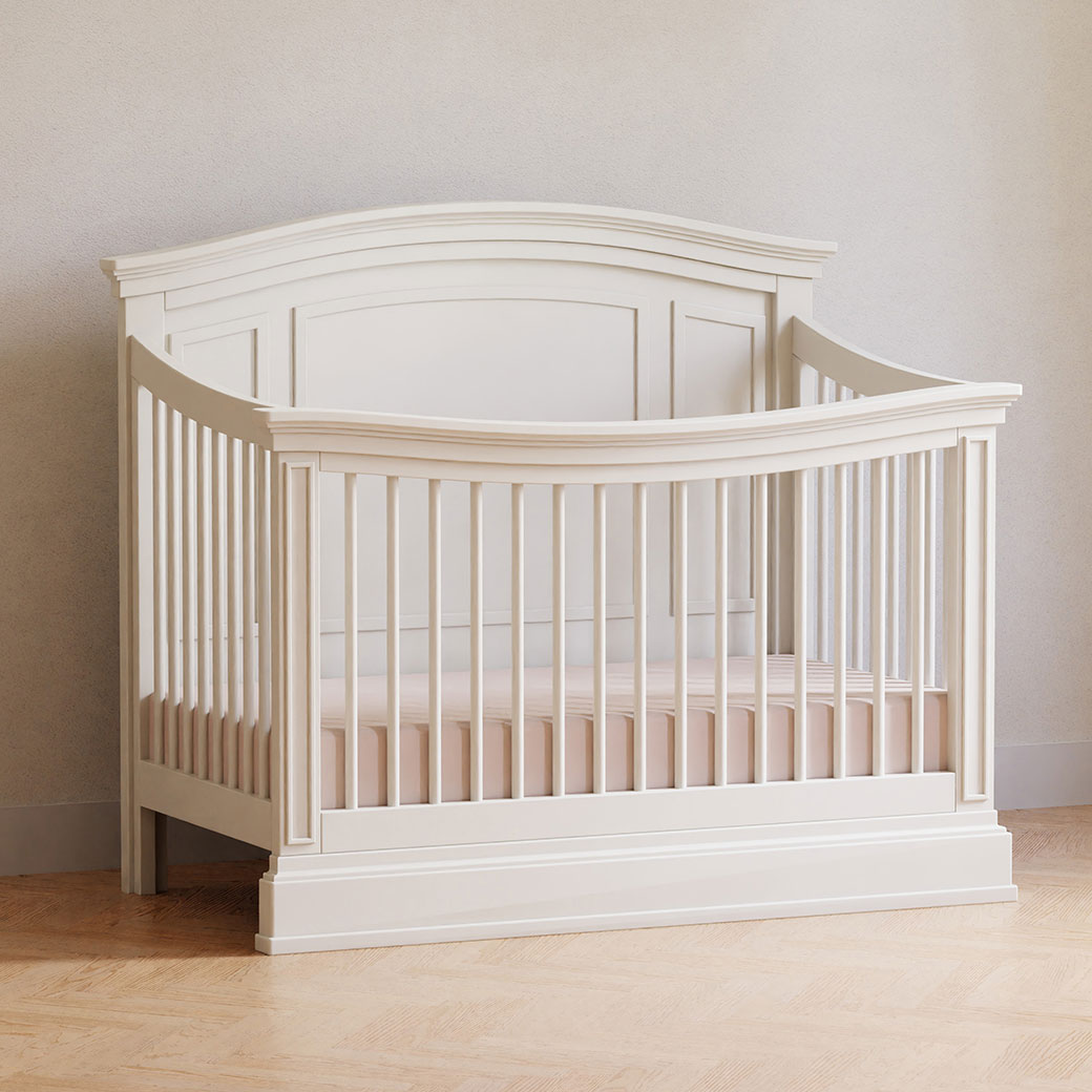 Namesake's Durham 4-in-1 Convertible Crib in a room against a wall  in -- Color_Warm White