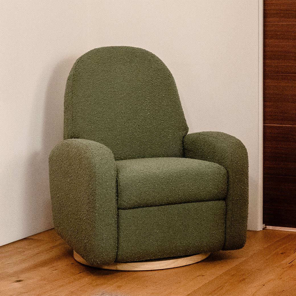 The Babyletto Nami Glider Recliner in a wooden-floor room  in -- Color_Olive Boucle with Light Wood Base