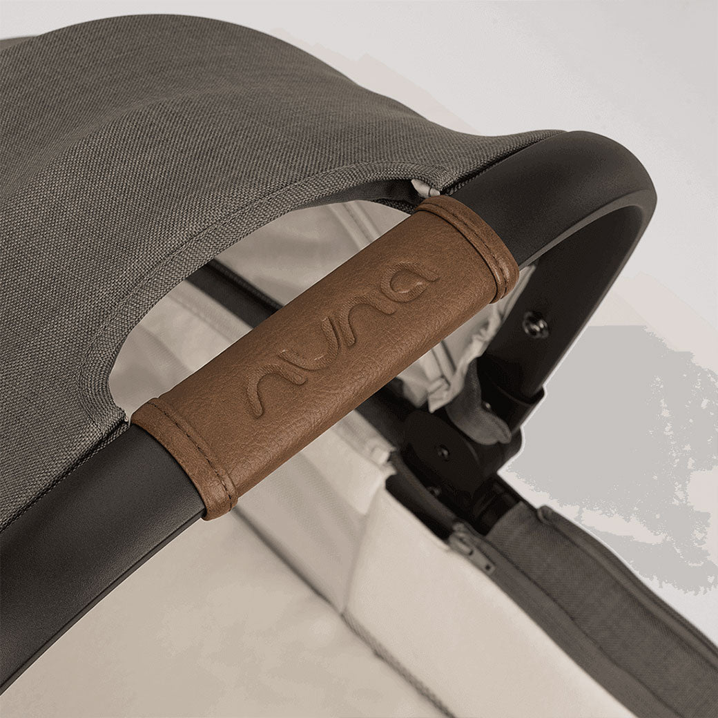 Closeup of Nuna logo on the Nuna DEMI Next Bassinet + Stand in -- Color_Granite