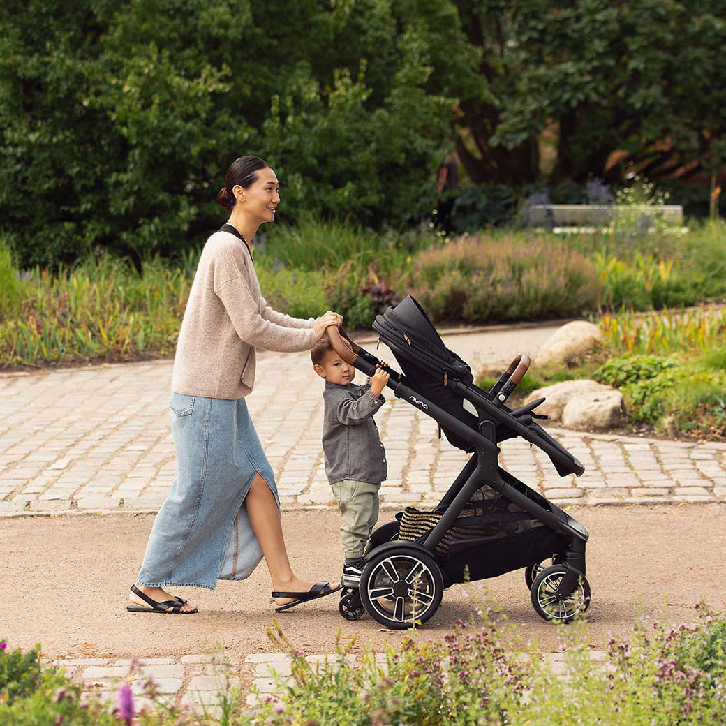 Mom and child in the park with the Nuna DEMI Next Stroller in -- Color_Caviar