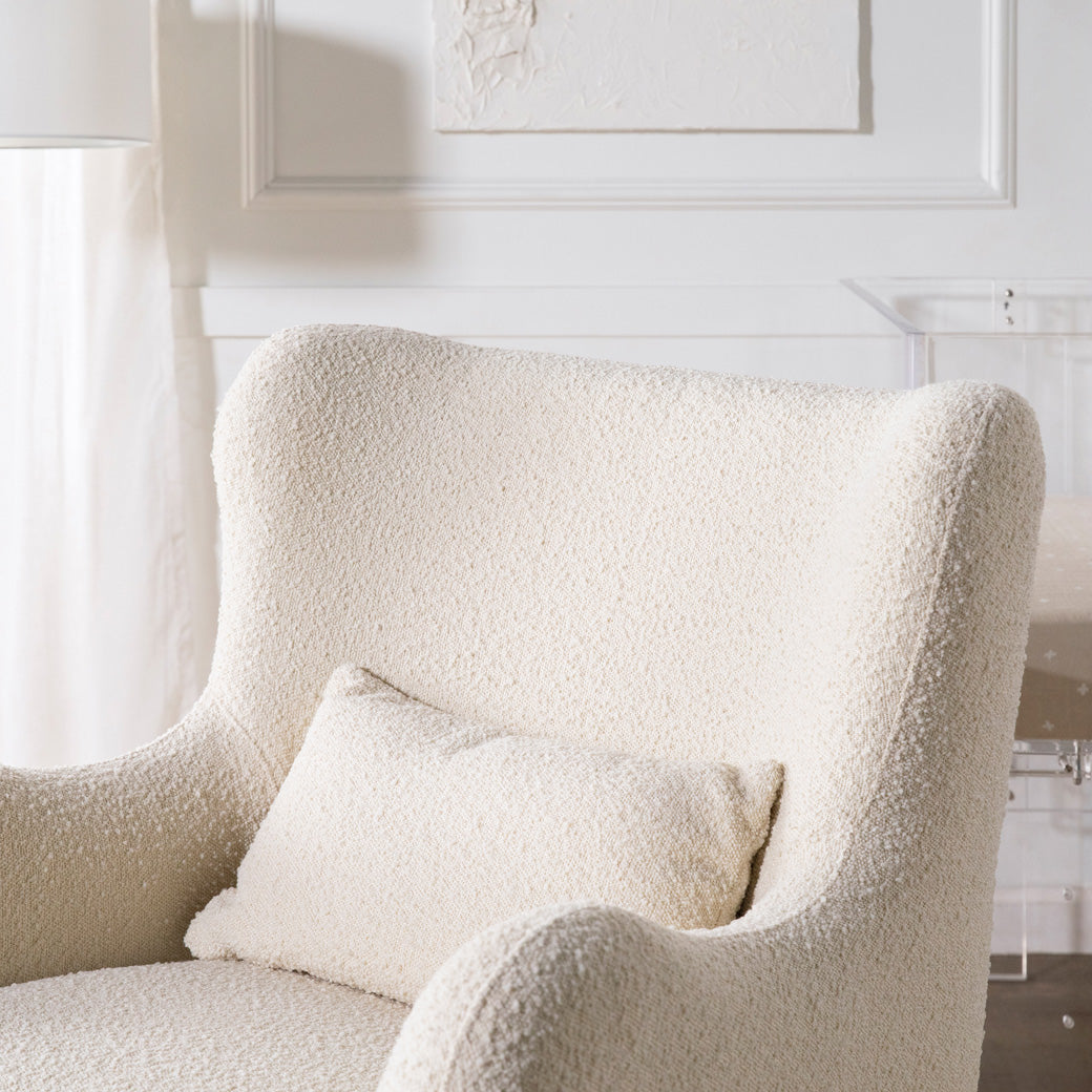 Closeup of backrest of The Nursery Works Solstice Swivel Glider in a white room  in --Color_Ivory Boucle with Ivory Wood Base