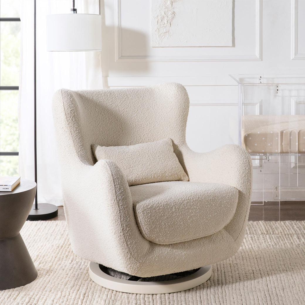 The Nursery Works Solstice Swivel Glider in a white room in --Color_Ivory Boucle with Ivory Wood Base