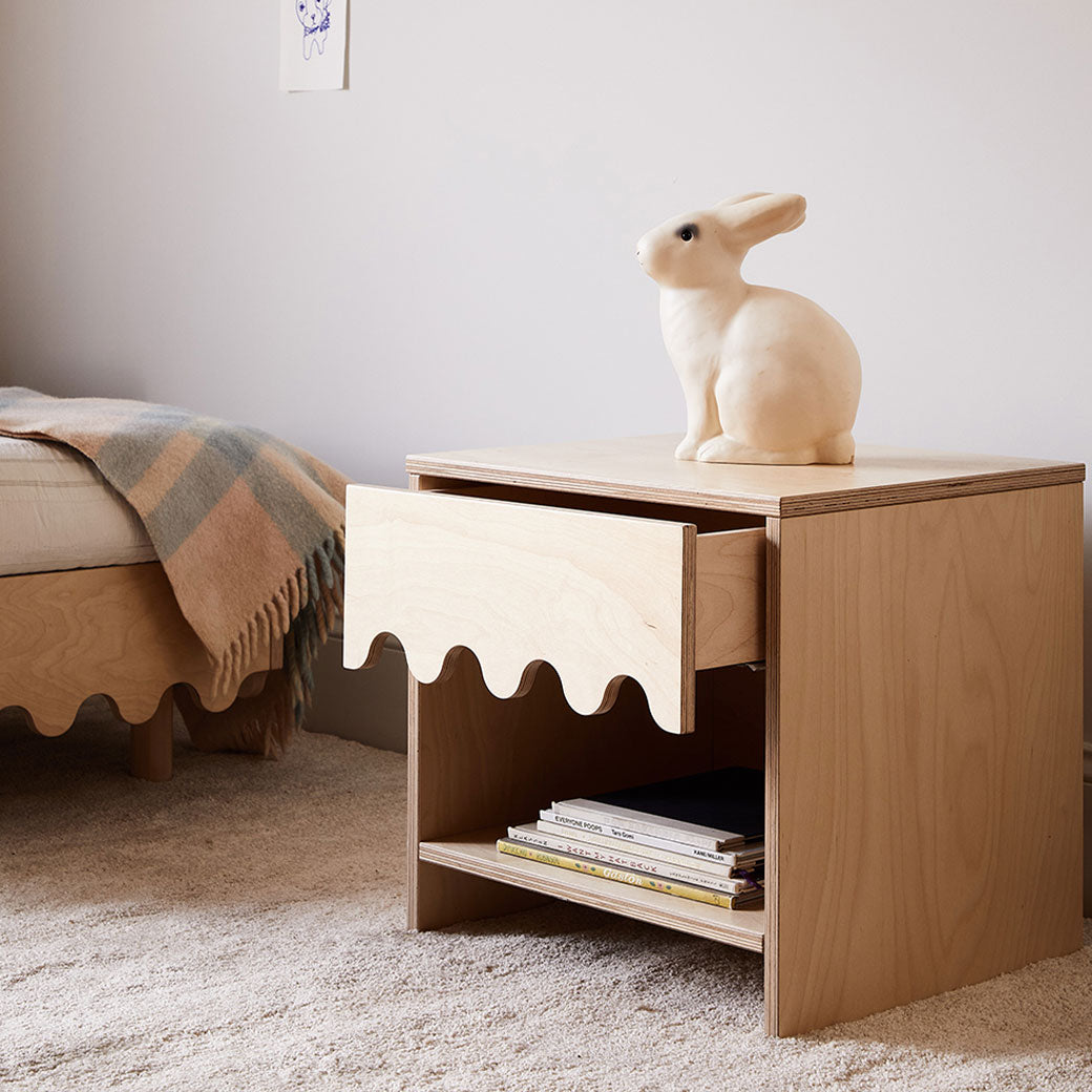 Oeuf Moss Nightstand next to a bed and an open drawer  in -- Color_Birch