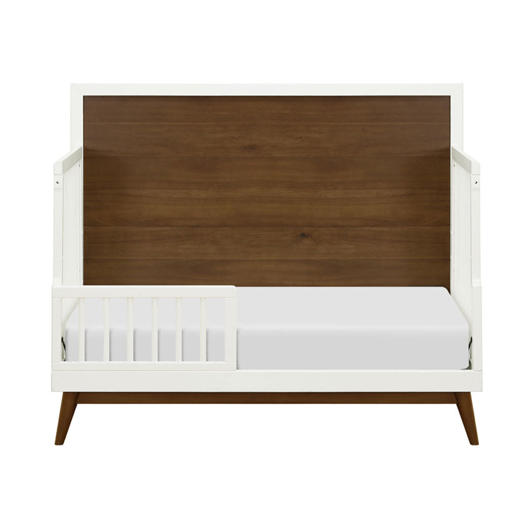 Front view of  Babyletto's Palma 4-in-1 Convertible Crib as toddler bed  in -- Color_Warm White with Natural Walnut