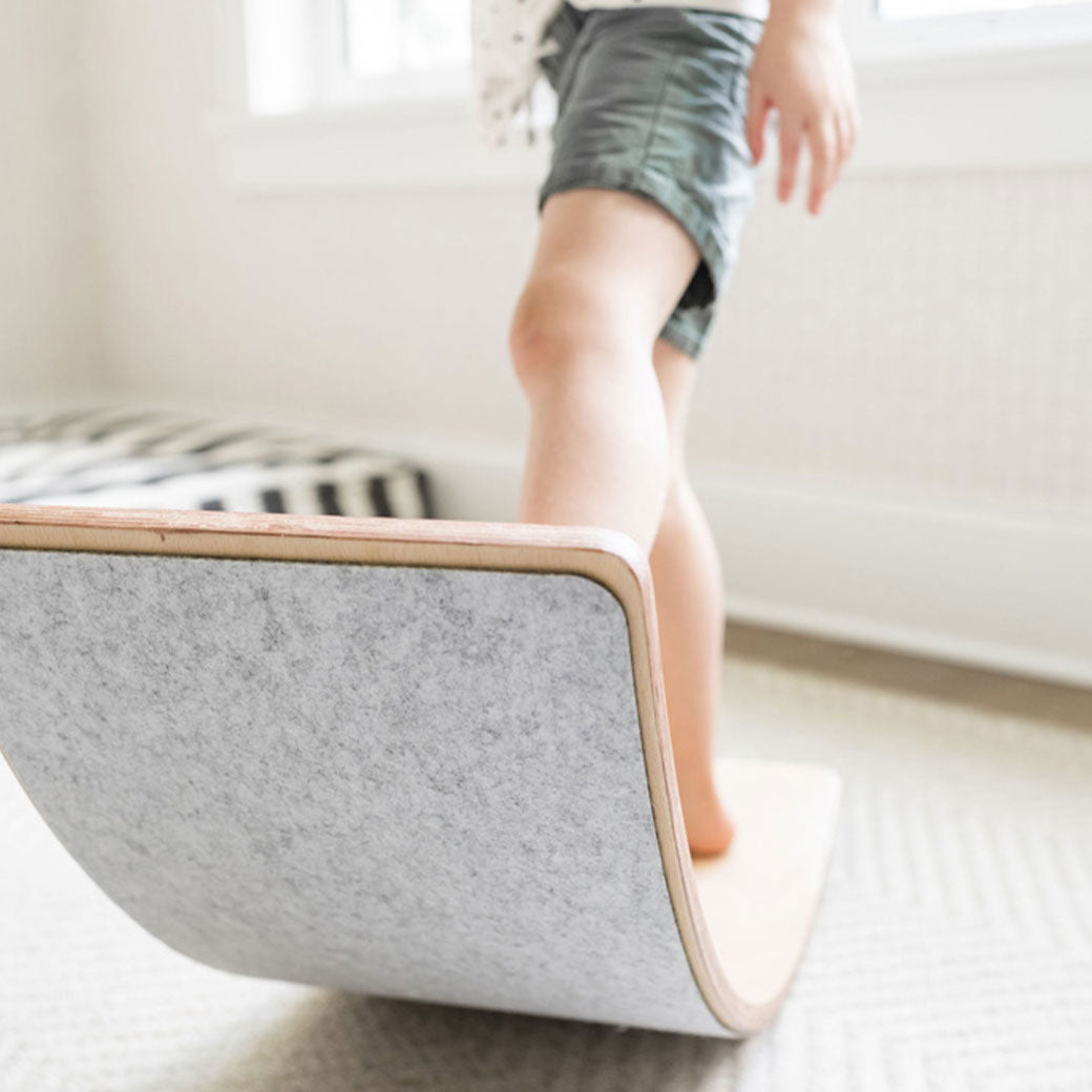 Child standing on the Poppyseed Play Balance Board in -- Color_Gray Felt Bottom