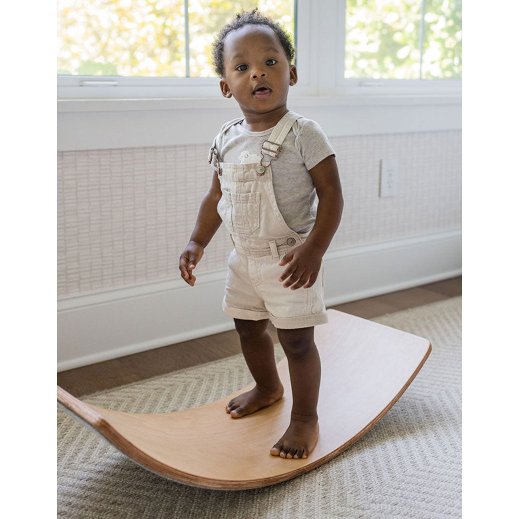 Child standing on the Poppyseed Play Balance Board in -- Color_Gray Felt Bottom