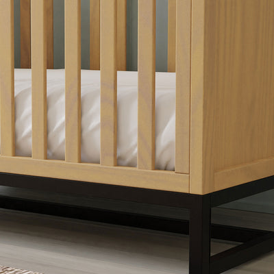 Closeup of the right lower corner DaVinci's Ryder 3-in-1 Convertible Crib in -- Color_Honey