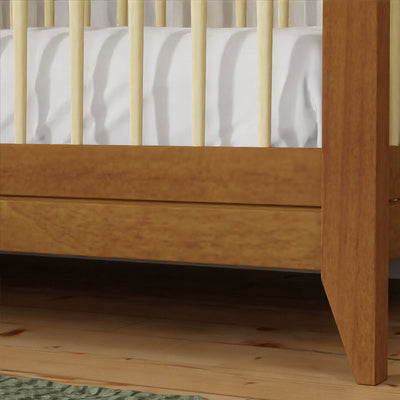 Closeup of Babyletto's Sprout 4-in-1 Convertible Crib leg in -- Color_Chestnut / Natural