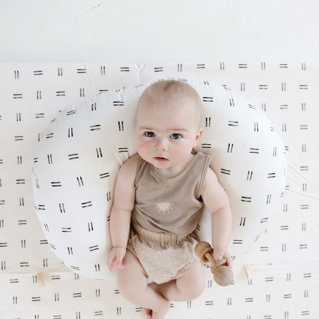 Baby holding a toy on the Toki Mats Padded Organic Cotton Play Mat in -- Color_Mudcloth