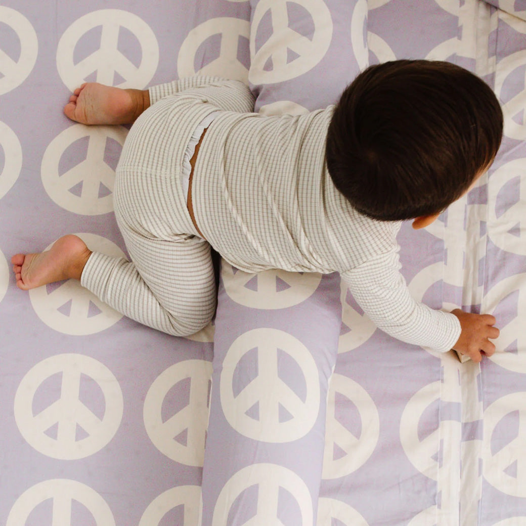 Baby crawling on the Toki Mats Padded Organic Cotton Play Mat in -- Color_Peace Sign