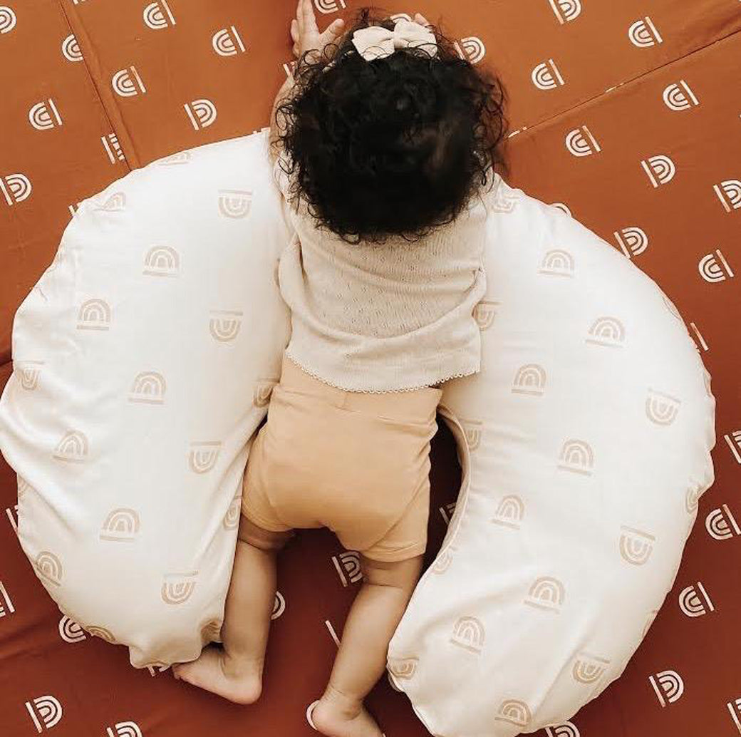 Baby laying on the Toki Mats Padded Organic Cotton Play Mat in -- Color_Rainbow Rust
