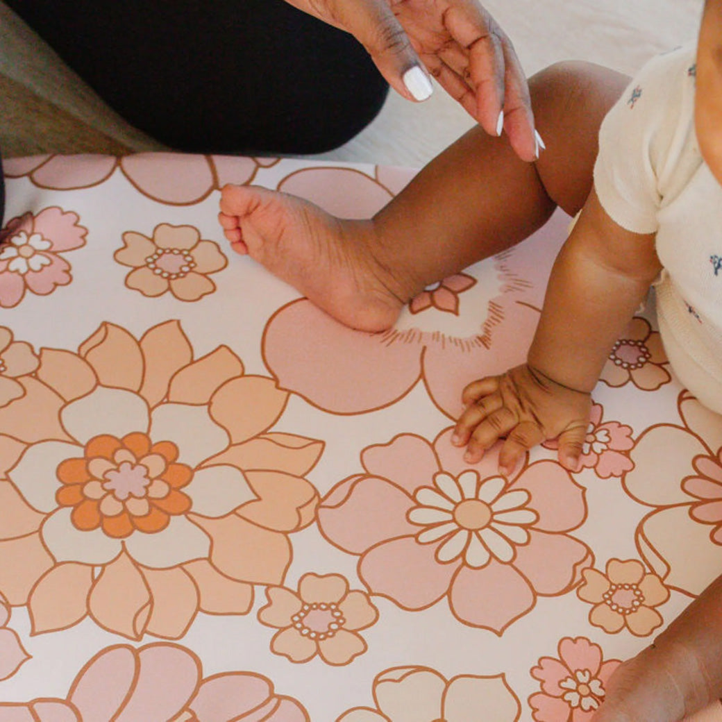 Closeup of baby sitting on the Toki Mats Vegan Leather Play Mat in -- Color_Blooms 
