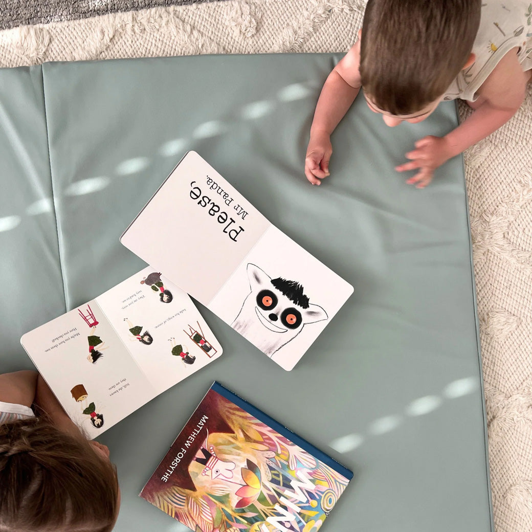 Kids reading books on the Toki Mats Vegan Leather Play Mat in -- Color_Sage