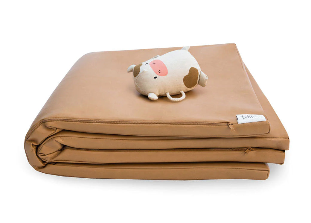 Toy on top of folded Toki Mats Vegan Leather Play Mat in -- Color_Sand
