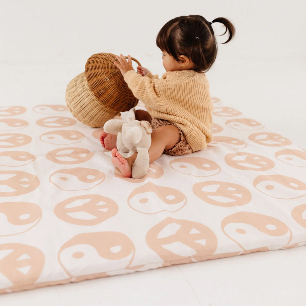 Baby playing with a basket on the Toki Mats Padded Organic Cotton Play Mat in -- Color_Yin Yang