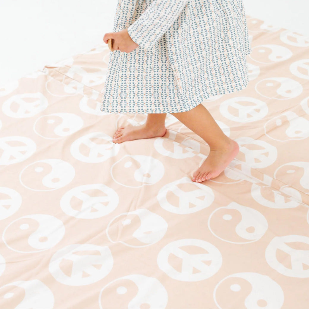 Toddler walking on the Toki Mats Padded Organic Cotton Play Mat in -- Color_Yin Yang