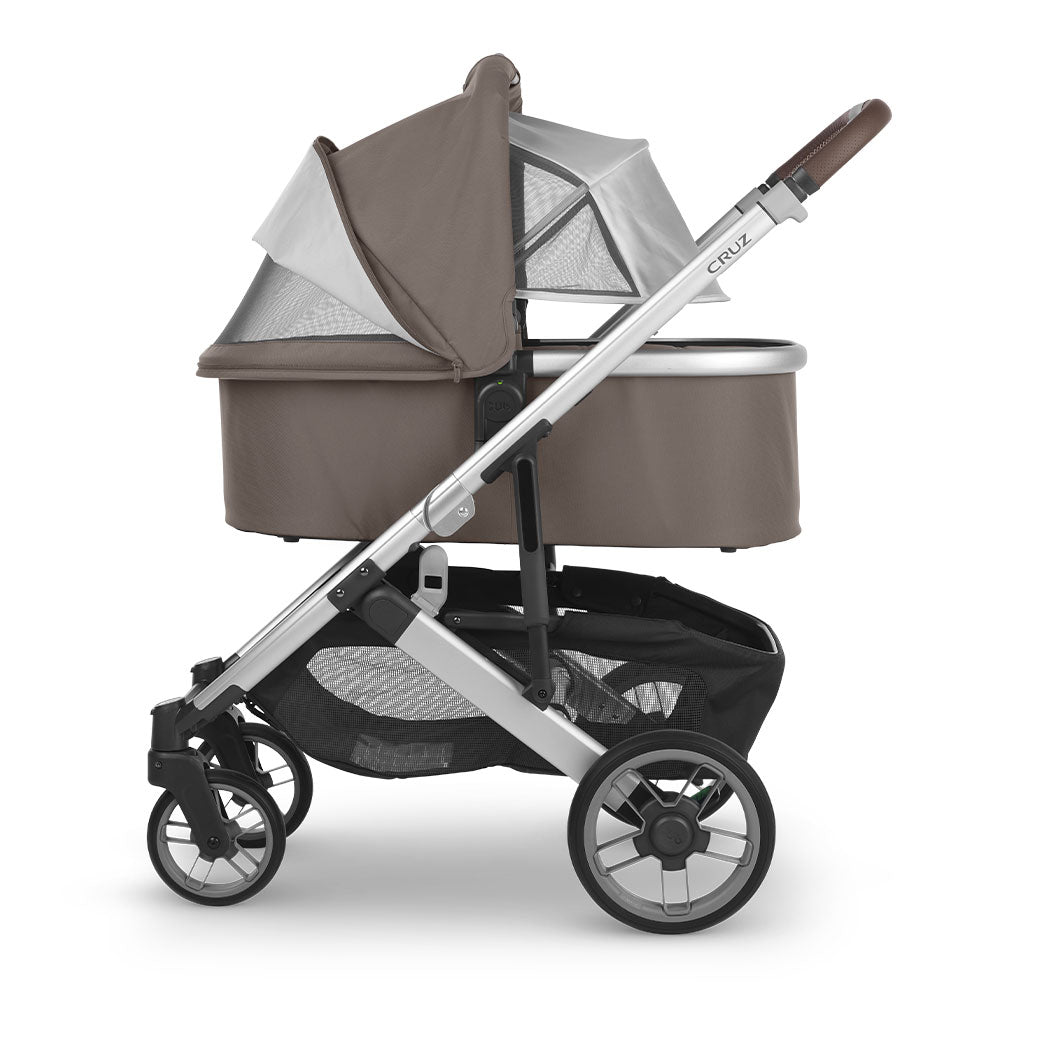 Side view of the UPPAbaby Bassinet on the Cruz V2 stroller with sunshade down and canopy vent open in -- Color_Theo