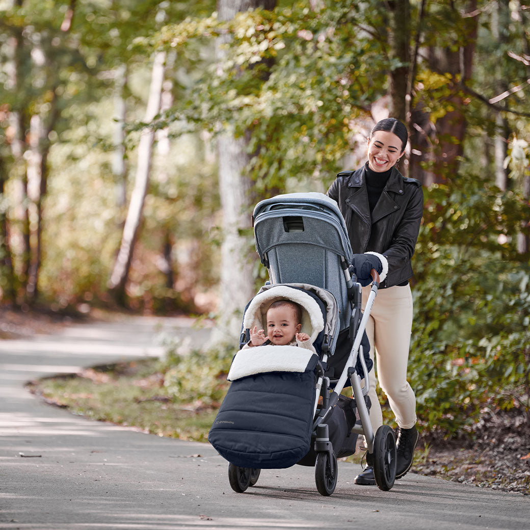 Mommy walking a baby in the Uppababy CozyGanoosh on the Vista V2 stroller  in -- Color_Noa
