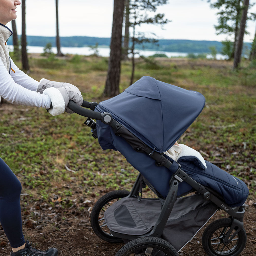 A mommy pushing a baby in the park in the Uppababy CozyGanoosh on Vista V2 Stroller  in -- Color_Noa