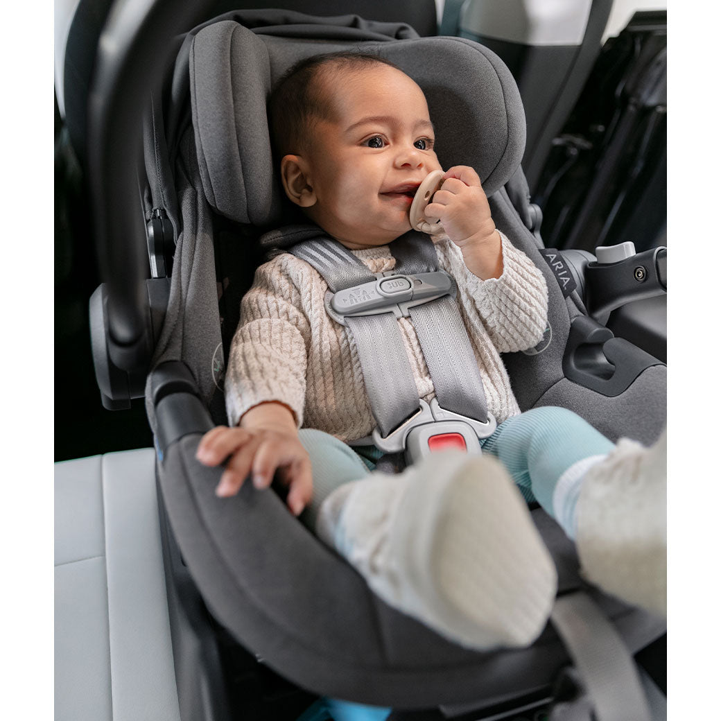 Baby sitting in the Uppababy Aria Infant Car Seat in -- Color_Greyson