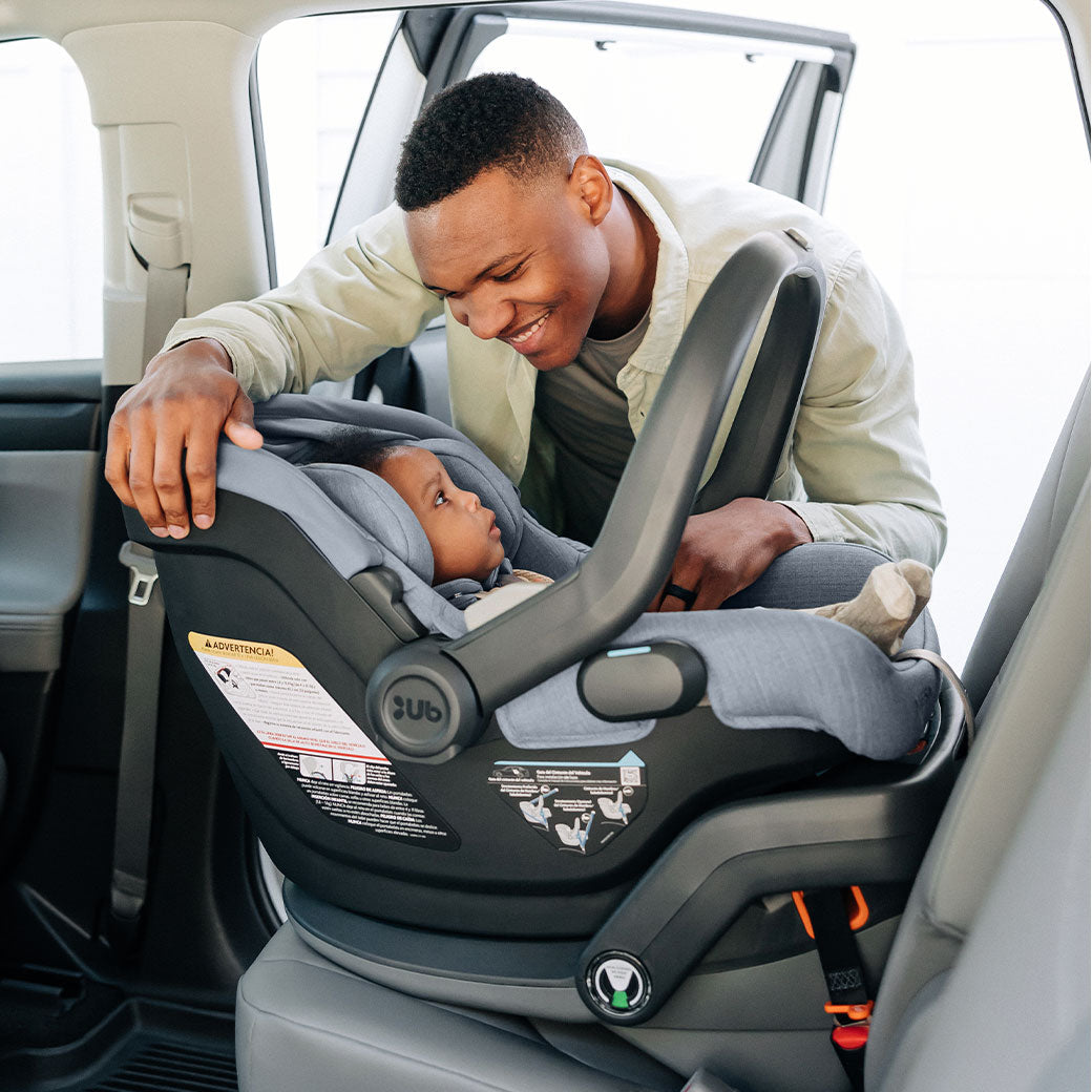 A dad smiling at baby in the UPPAbaby MESA V2 Infant Car Seat in -- Color_Gregory
