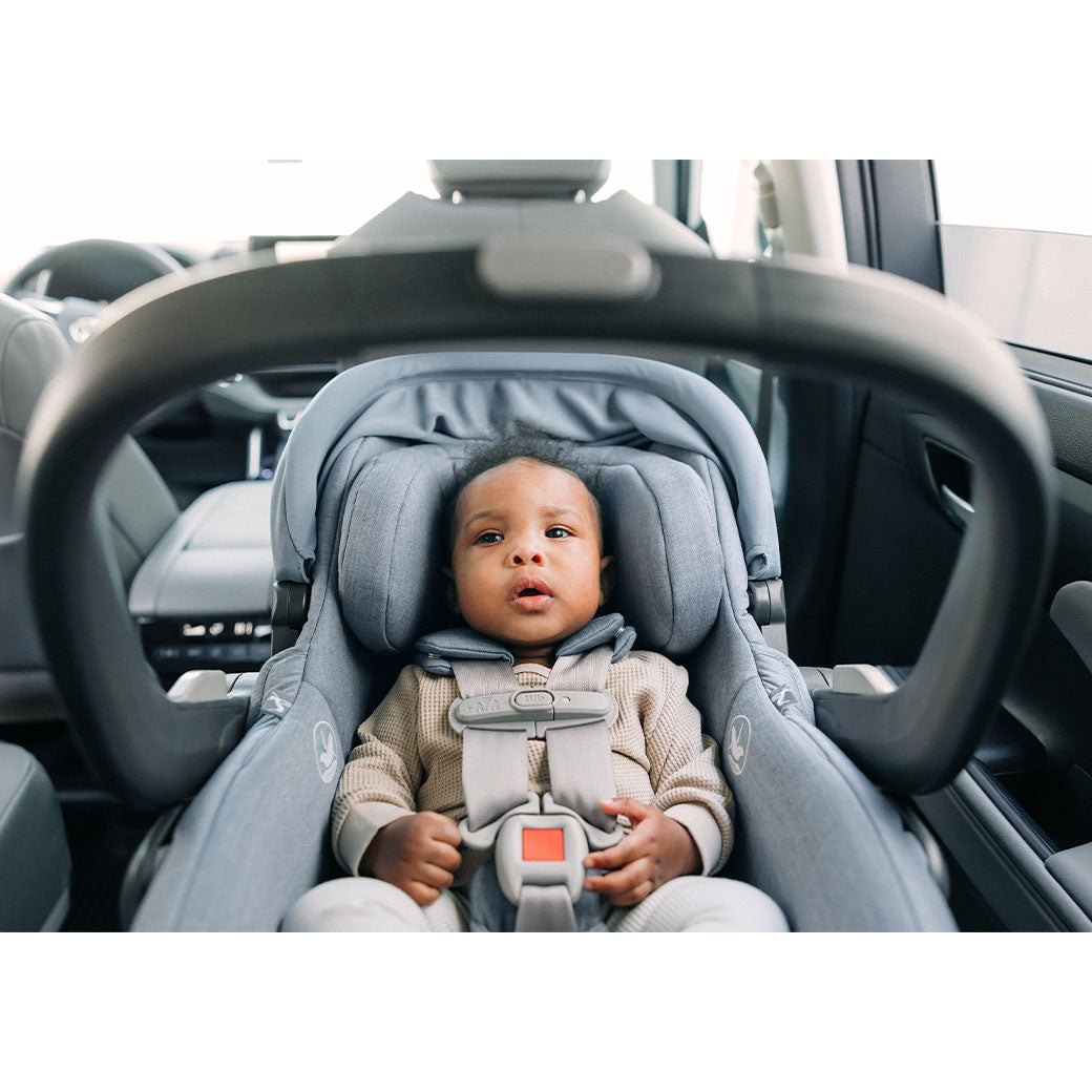 A baby in a car in the UPPAbaby MESA V2 Infant Car Seat in -- Color_Gregory