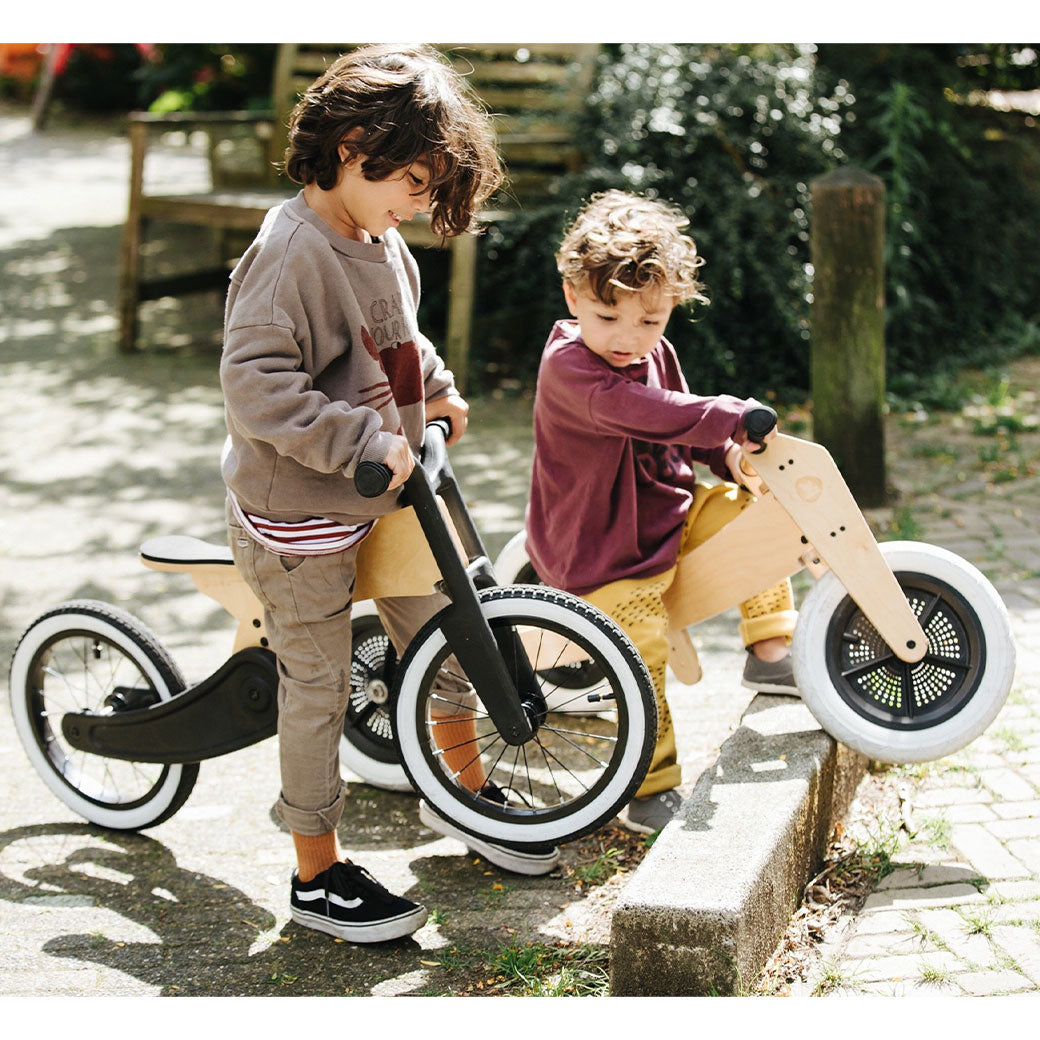 Two toddler on bikes and the older toddler is riding the Wishbone 2-in-1 Cruise Bike