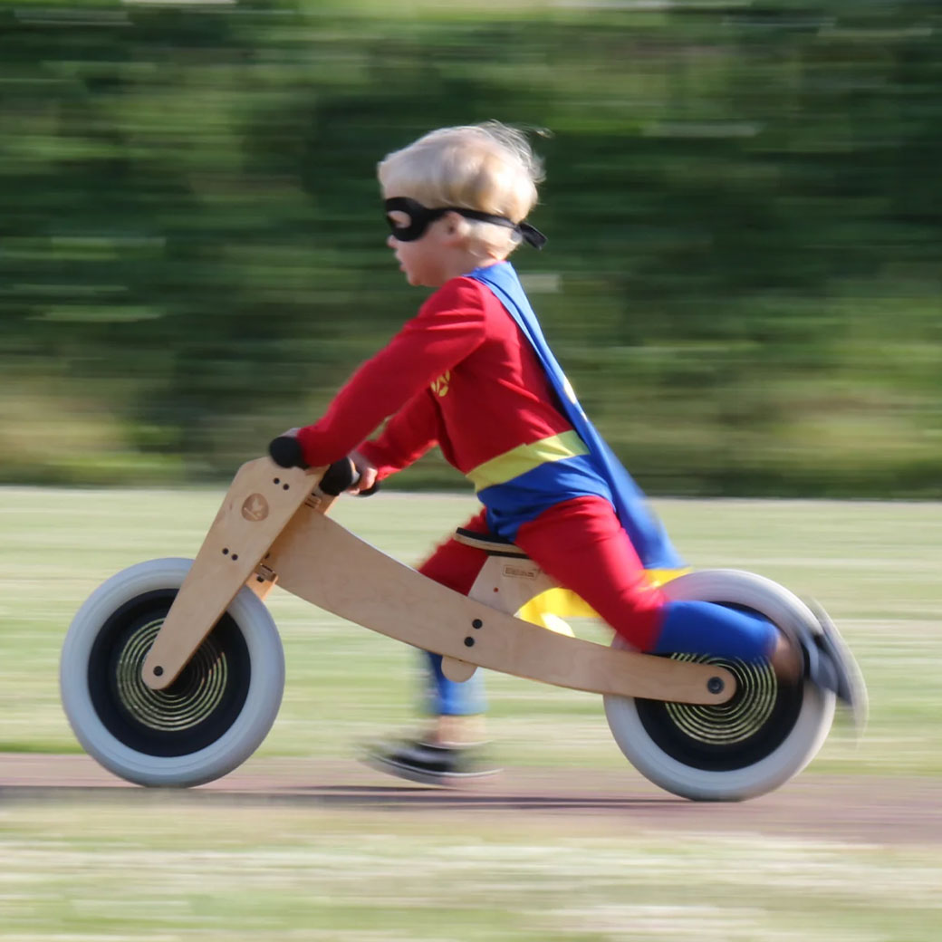 Toddler in a costume on the Wishbone 2-in-1 Bike in -- Color_Natural