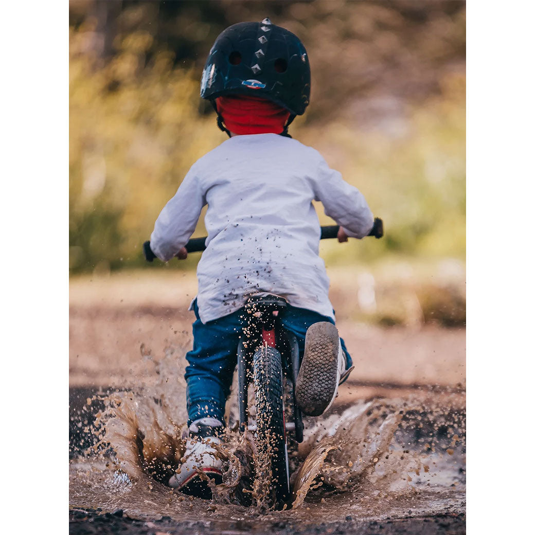 Boy riding the Wishbone Bike RE2 3 in 1 through mud in -- Lifestyle