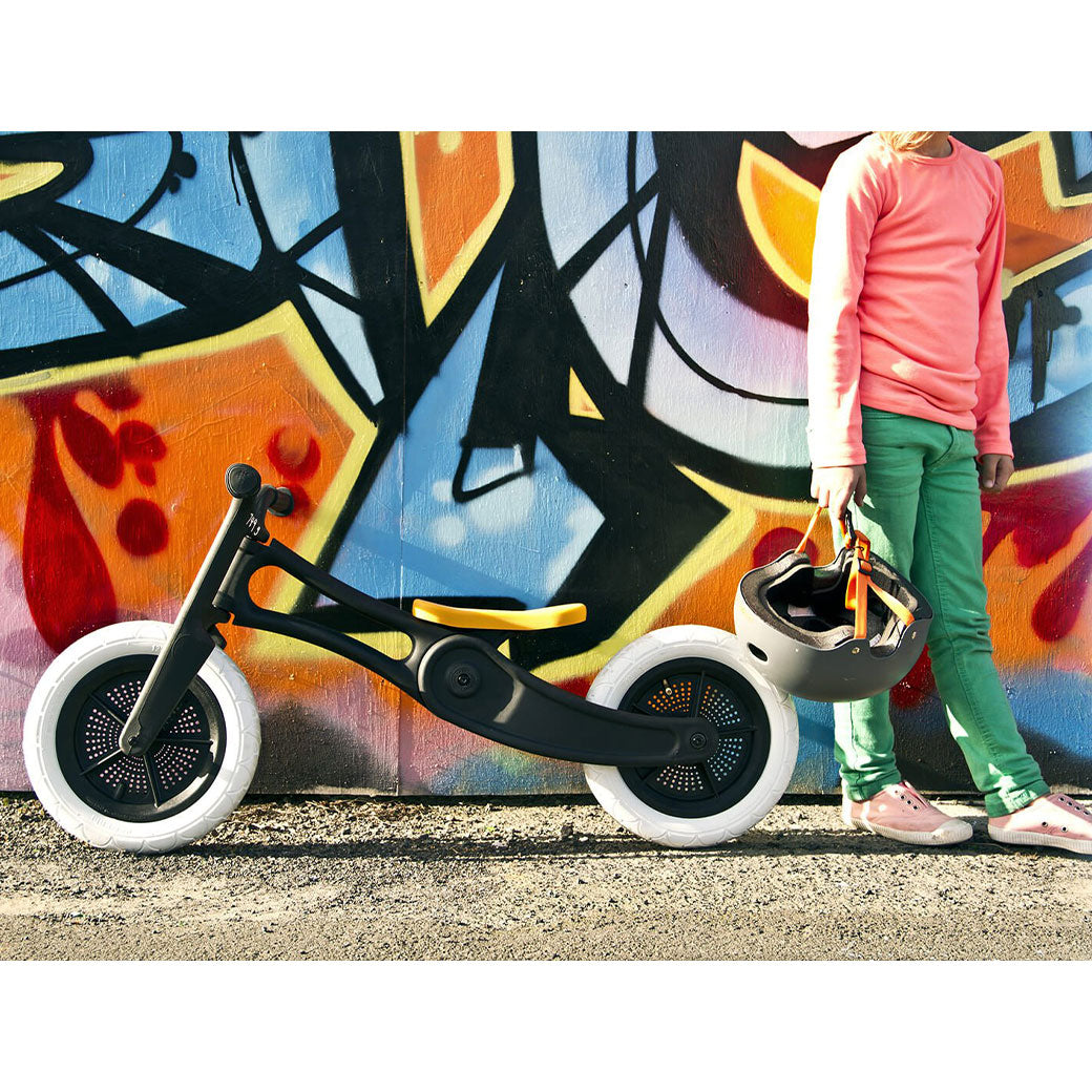 Girl standing next to a colorful wall and the Wishbone Bike RE2 3 in 1 in -- Lifestyle