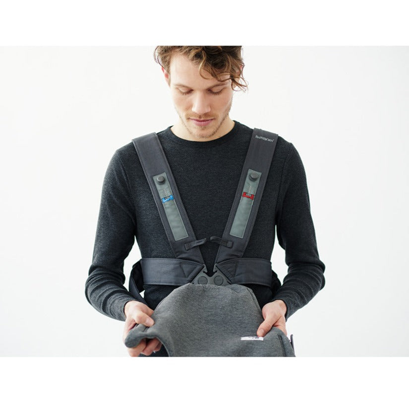 Dad putting on the BABYBJÖRN Baby Carrier Mini in -- Color_Dark Gray 3D Jersey