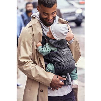 Dad laughing while holding baby in the BABYBJÖRN Baby Carrier Free in -- Color_Anthracite 3D Mesh