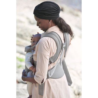 Back side view of mother holding baby in BABYBJÖRN Baby Carrier Free in -- Color_Gray 3D Mesh