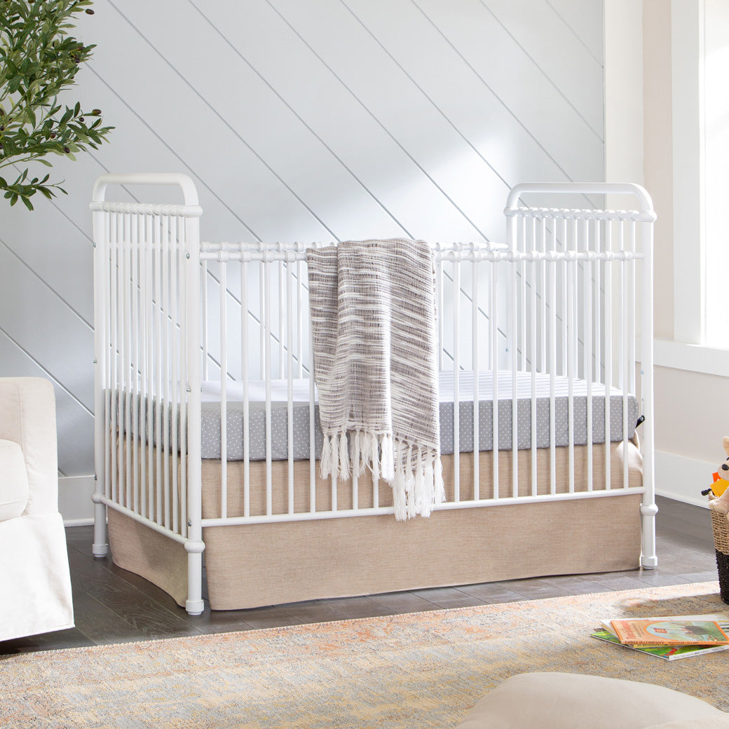 Namesake`s Abigail 3 in 1 Crib in a room with a blanket hanging over the rail  in -- Color_Washed White