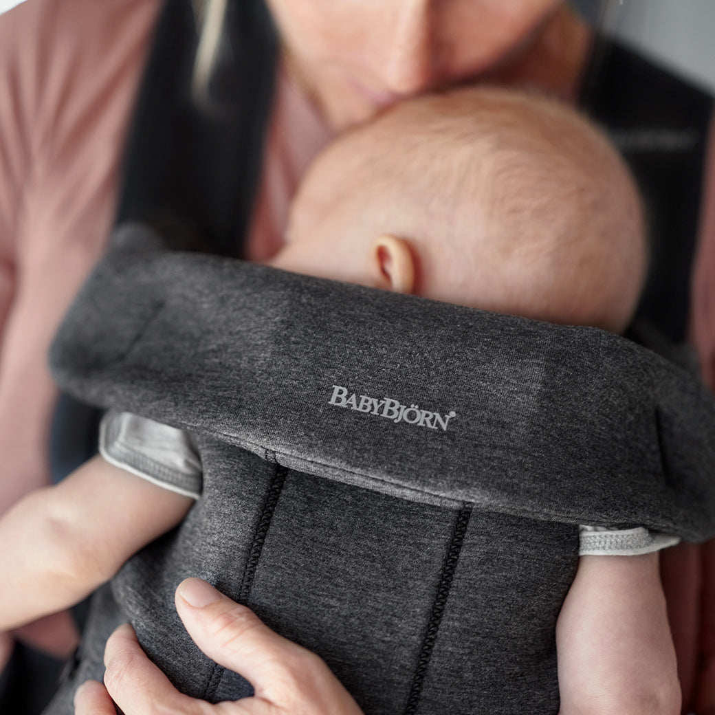Closeup of the back of BABYBJÖRN Baby Carrier Mini with baby in it in -- Color_Charcoal 3D Jersey