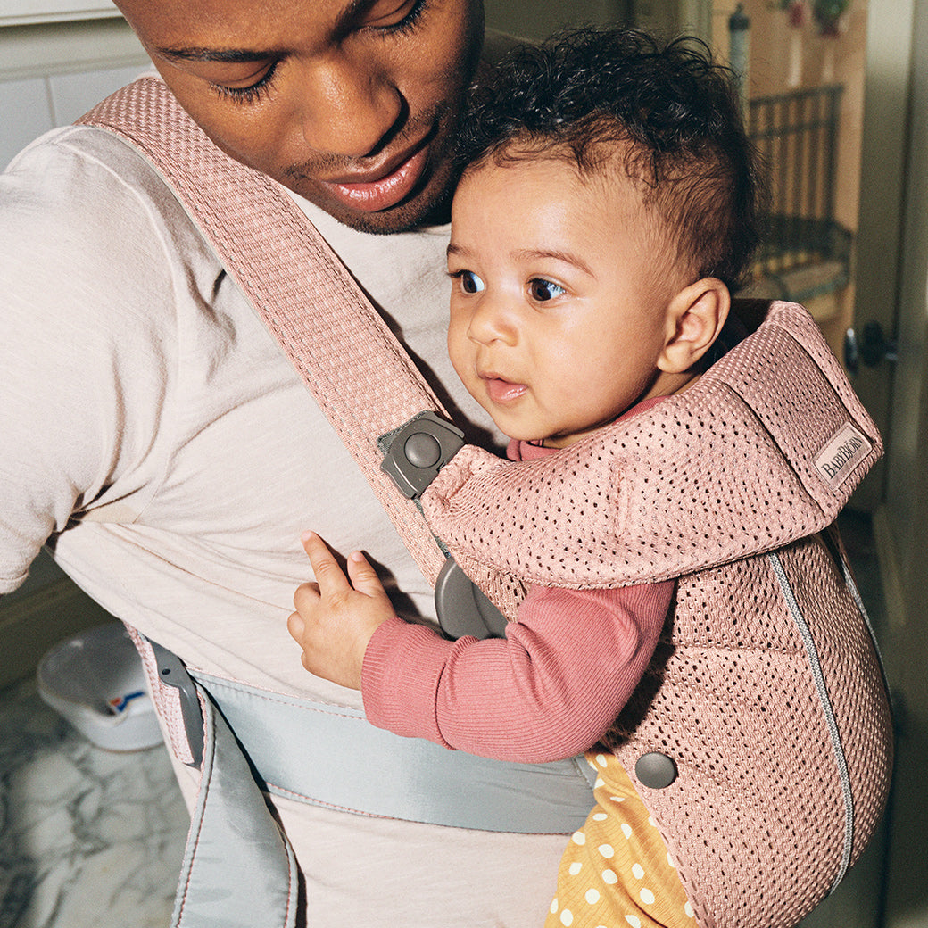 Closeup of dad carrying baby in BABYBJÖRN Baby Carrier Mini with top part down in -- Color_Dusty Pink 3D Mesh