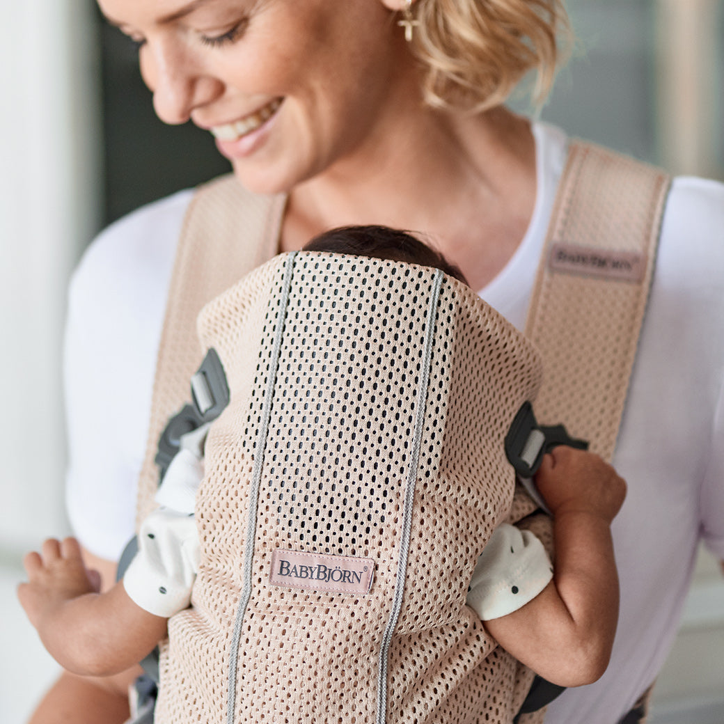 Closeup of mom carrying baby in BABYBJÖRN Baby Carrier Mini in -- Color_Pearly Pink 3D Mesh