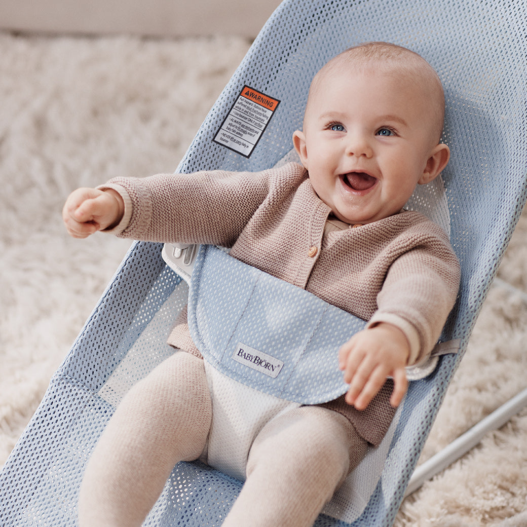 Closeup of baby laughing in BABYBJÖRN Bouncer Balance Soft in -- Color_Sky Blue/White Mesh