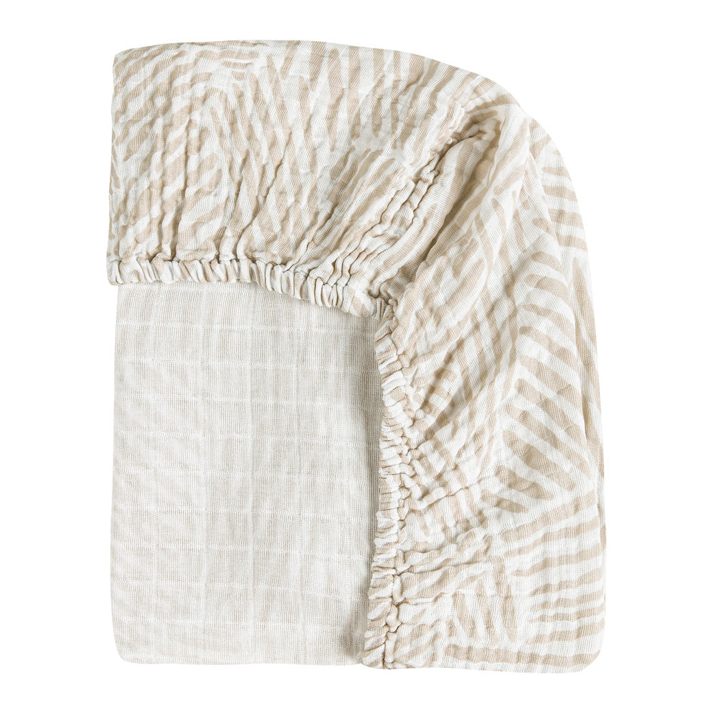 Back corner view of the Babyletto All-Stages Bassinet Sheet In GOTS Certified Organic Muslin Cotton in -- Color_Oat Stripe