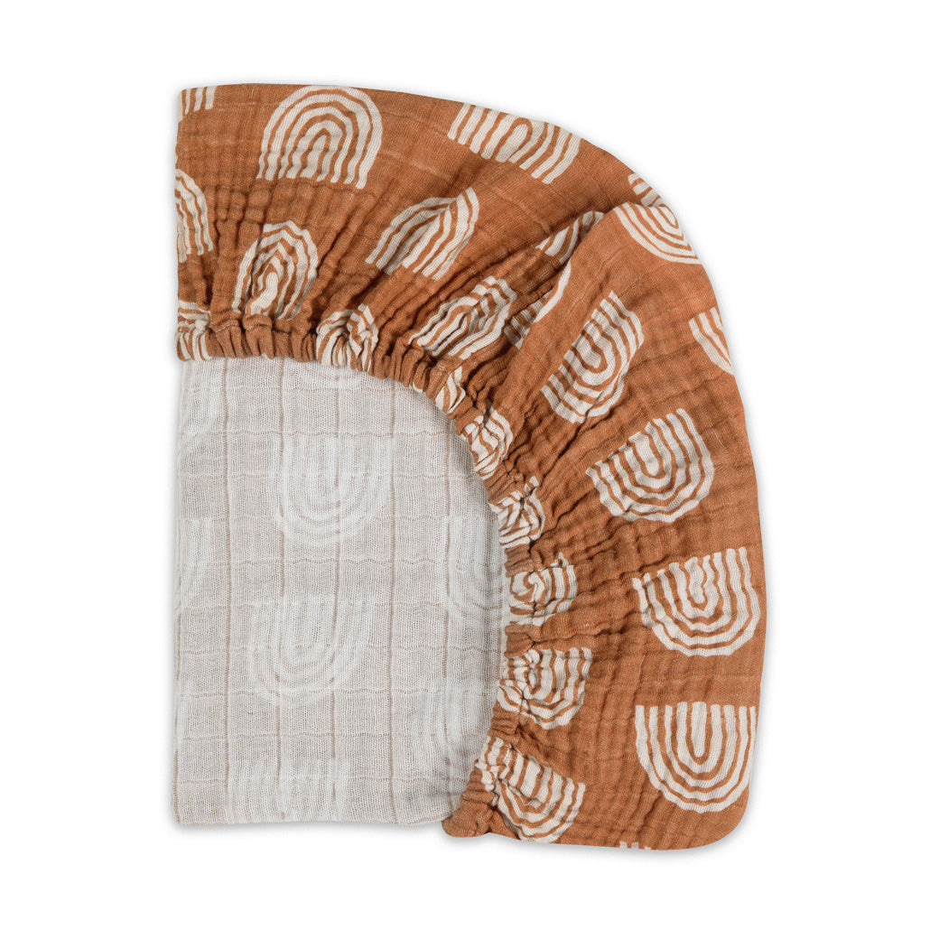 Back corner view of the Babyletto All-Stages Bassinet Sheet In GOTS Certified Organic Muslin Cotton in -- Color_Terracotta Rainbow
