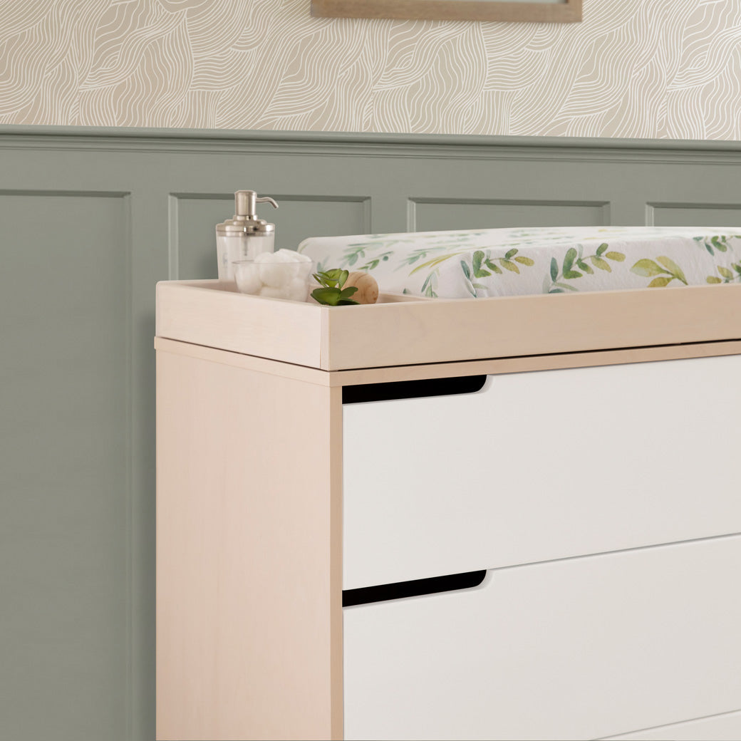 Lifestyle closeup corner view of The Babyletto Hudson Changer Dresser in -- Color_Washed Natural/White