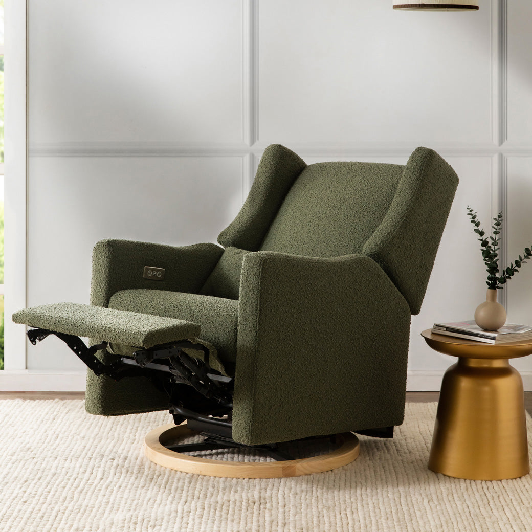 Reclined Babyletto Kiwi Glider Recliner next to a table in -- Color_Olive Boucle With Light Base