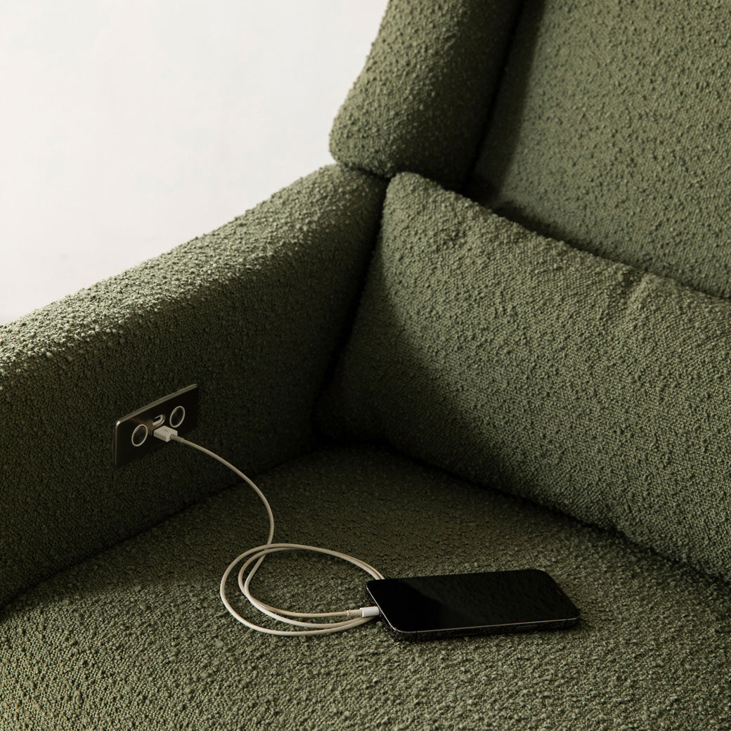 Closeup of a phone charging on the Babyletto Kiwi Glider Recliner in -- Color_Olive Boucle With Light Base