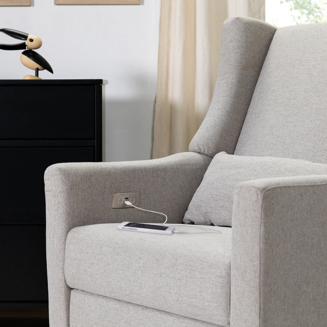 A phone charging on the Babyletto Kiwi Glider Recliner in -- Color_Performance Grey Eco-Weave