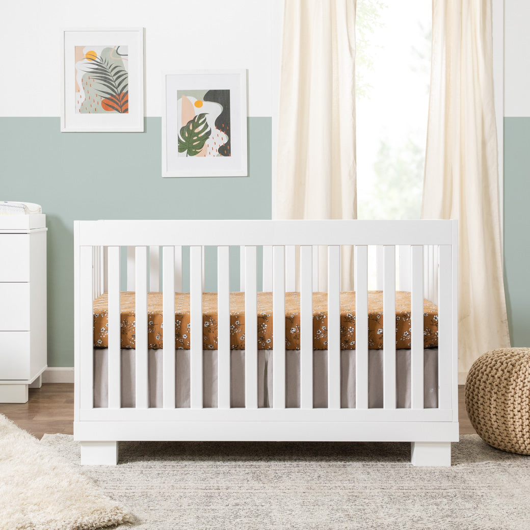 Babyletto Modo 3-in-1 Convertible Crib with Toddler Bed Conversion Kit next to a dresser and basket  in -- Color_White