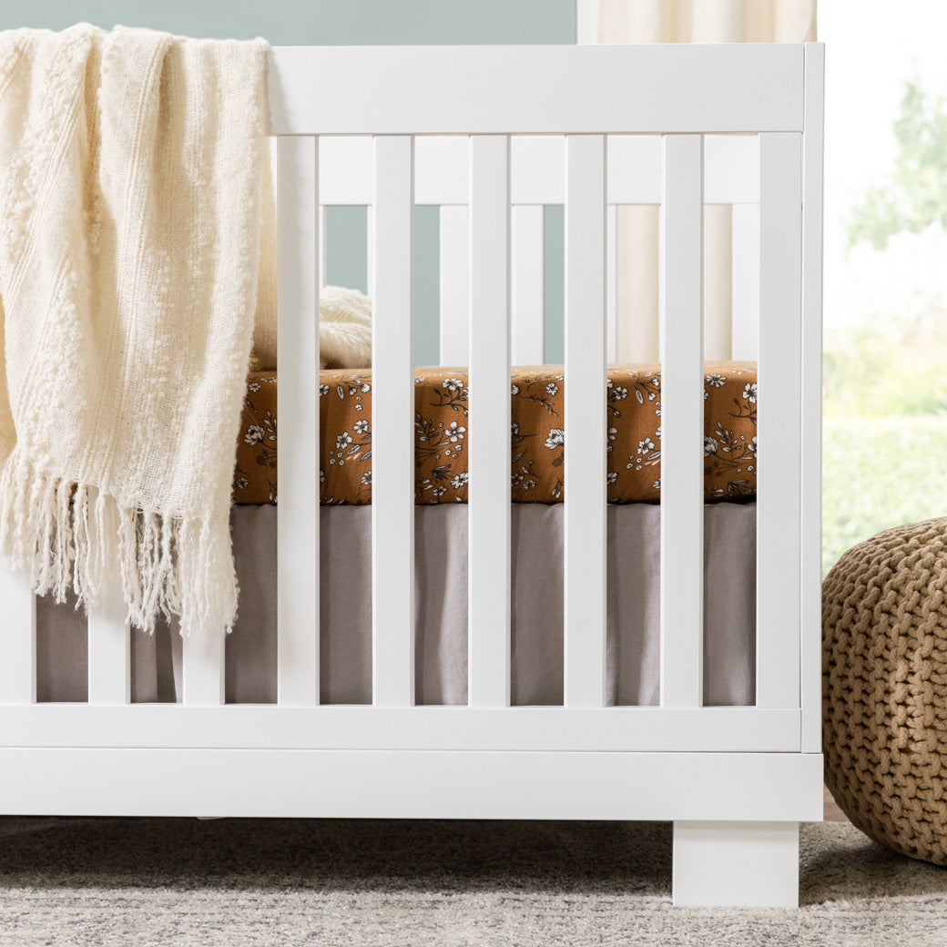 Closeup of Babyletto Modo 3-in-1 Convertible Crib with Toddler Bed Conversion Kit next to a basket  in -- Color_White