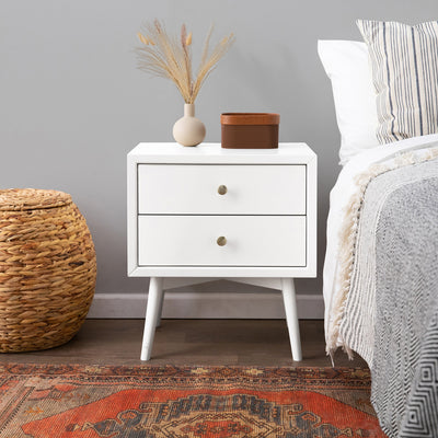 Front view of Babyletto's Palma Nightstand With USB Port next to a bed and basket in -- Color_Warm White