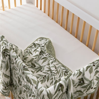 Babyletto's Quilt In 3-Layer GOTS Certified Organic Muslin Cotton in a crib in -- Color_Olive Branches