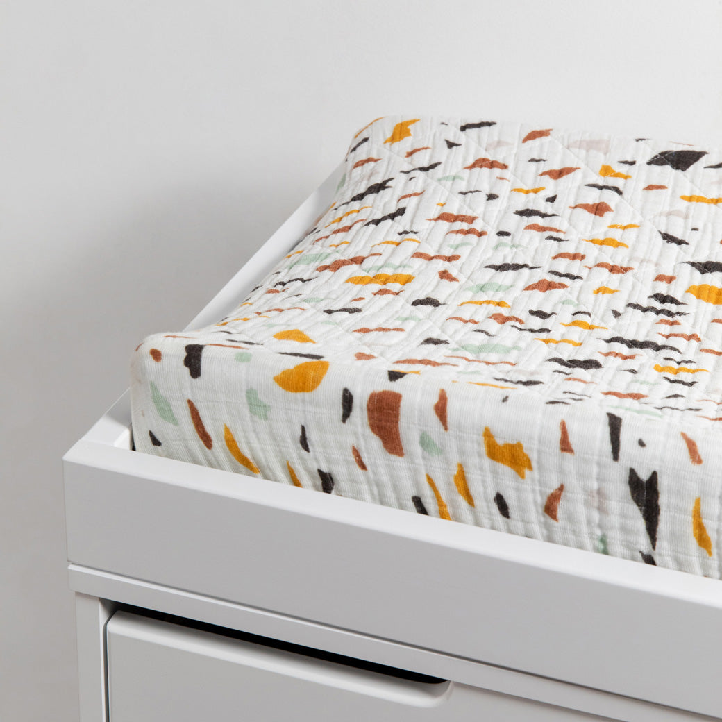 Babyletto Quilted Changing Pad Cover In GOTS Certified Organic Muslin Cotton in a changing tray in -- Color_Terrazzo