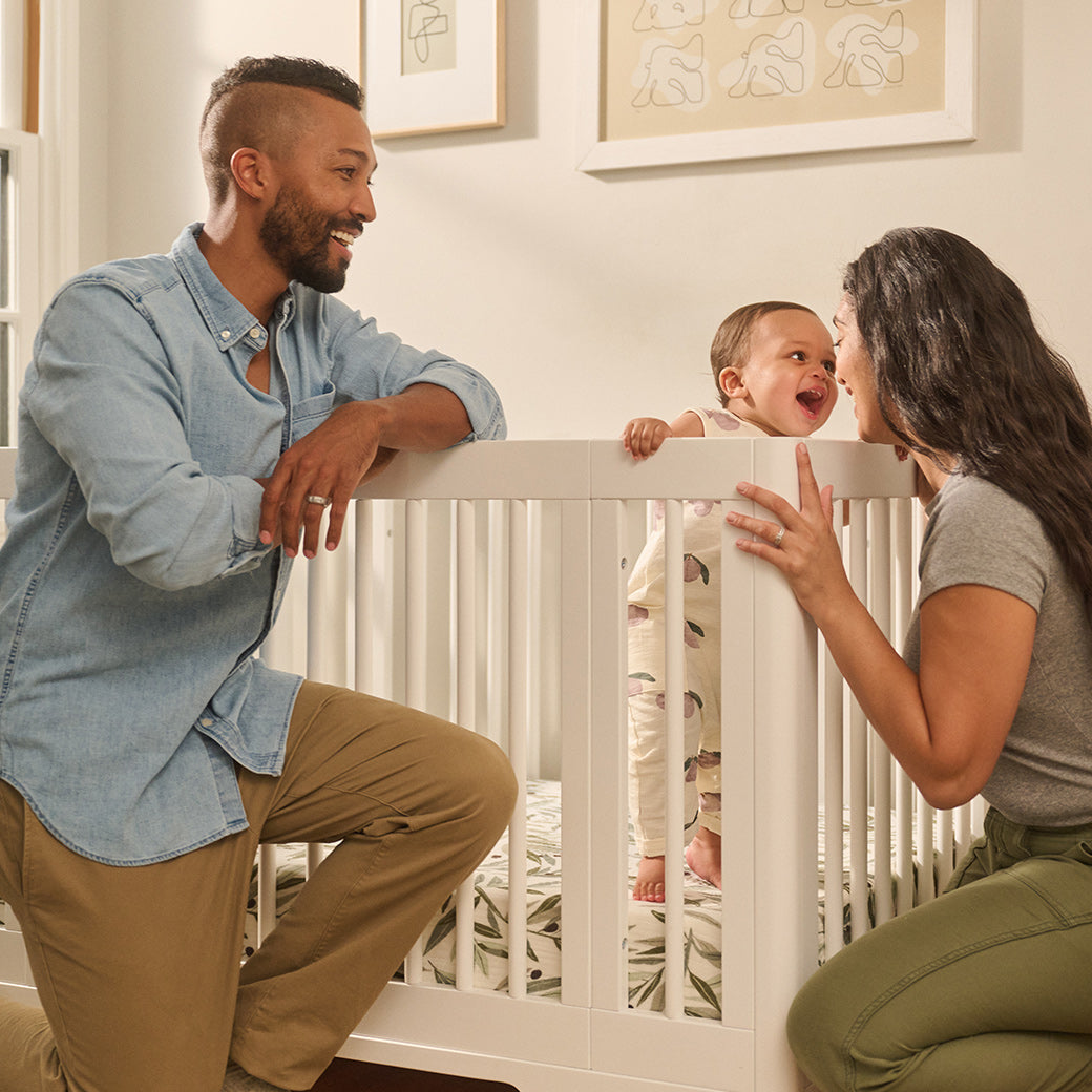 Mother and father with baby with Babyletto's Yuzu 8-In-1 Convertible Crib in -- Color_White